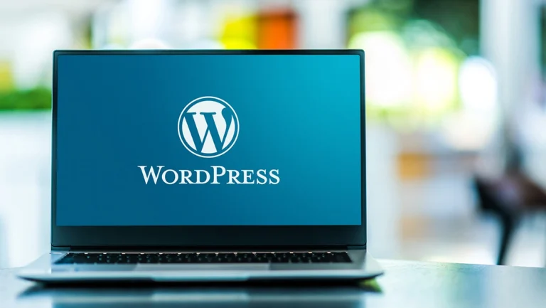 Fartölva með WordPress merki á skjánum, sem táknar vinsældir kerfisins meðal fyrirtækja og þekktra nafna.